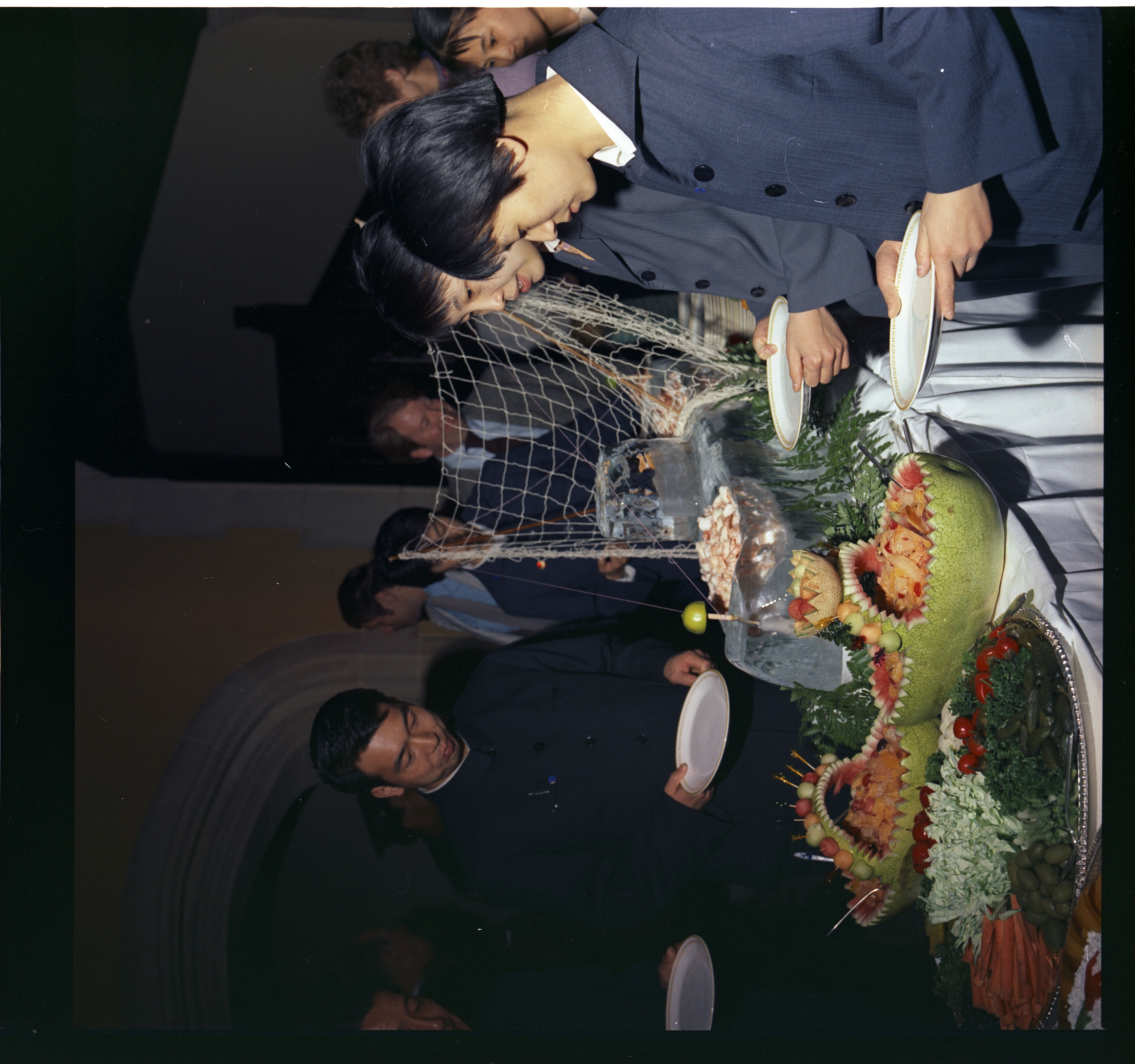 Chinese team selecting food from the buffet line at the reception.